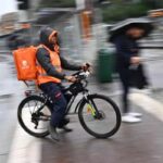 Un rider al lavoro sotto la pioggia