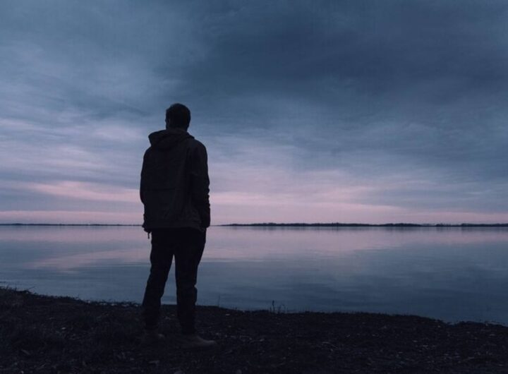 Un uomo al tramonto vicino alla riva