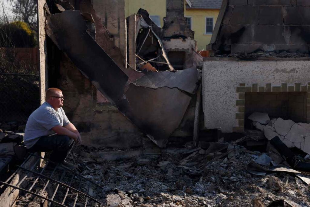 uomo seduto tra le macerie della sua casa distrutta negli incendi di los angeles