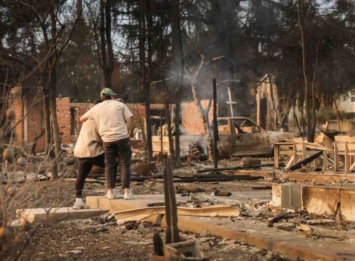 coppia abbracciata davanti alle macerie della loro casa distrutta negli incendi di Los Angeles