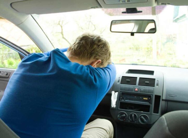 Un uomo dorme in auto