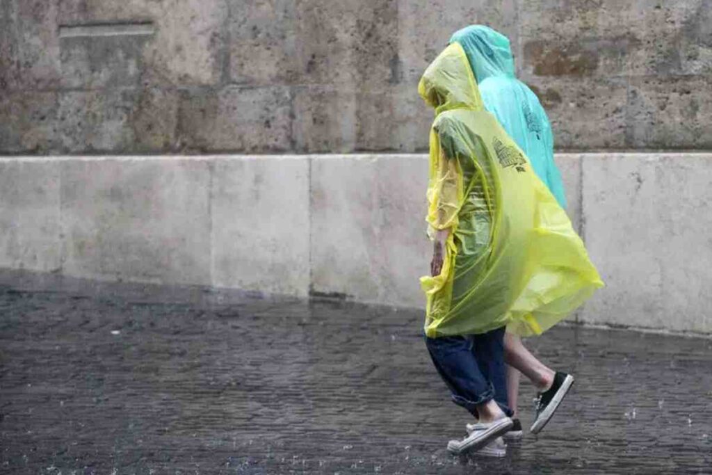 Due persone camminano con l'impermeabile