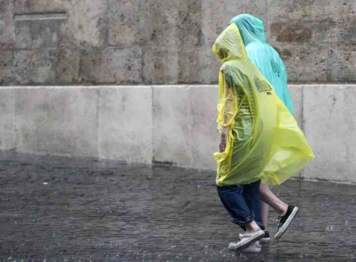 Due persone camminano con l'impermeabile