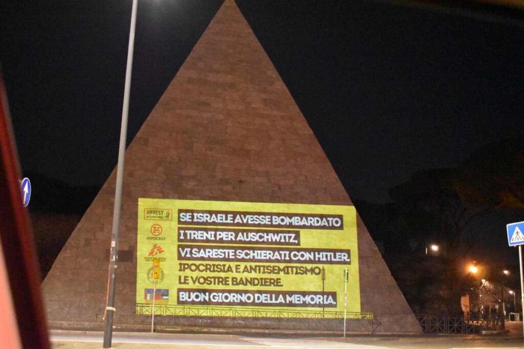 La facciata della Piramide Cestia a Roma con le scritte contro le Ong