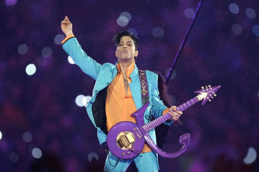 Prince sul palco durante un'esibizione, con la sua caratteristica chitarra viola