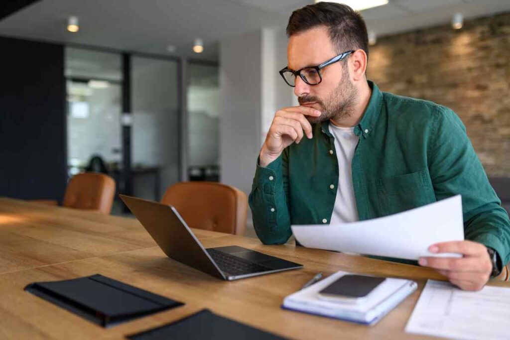 Un uomo lege le fatture al computer