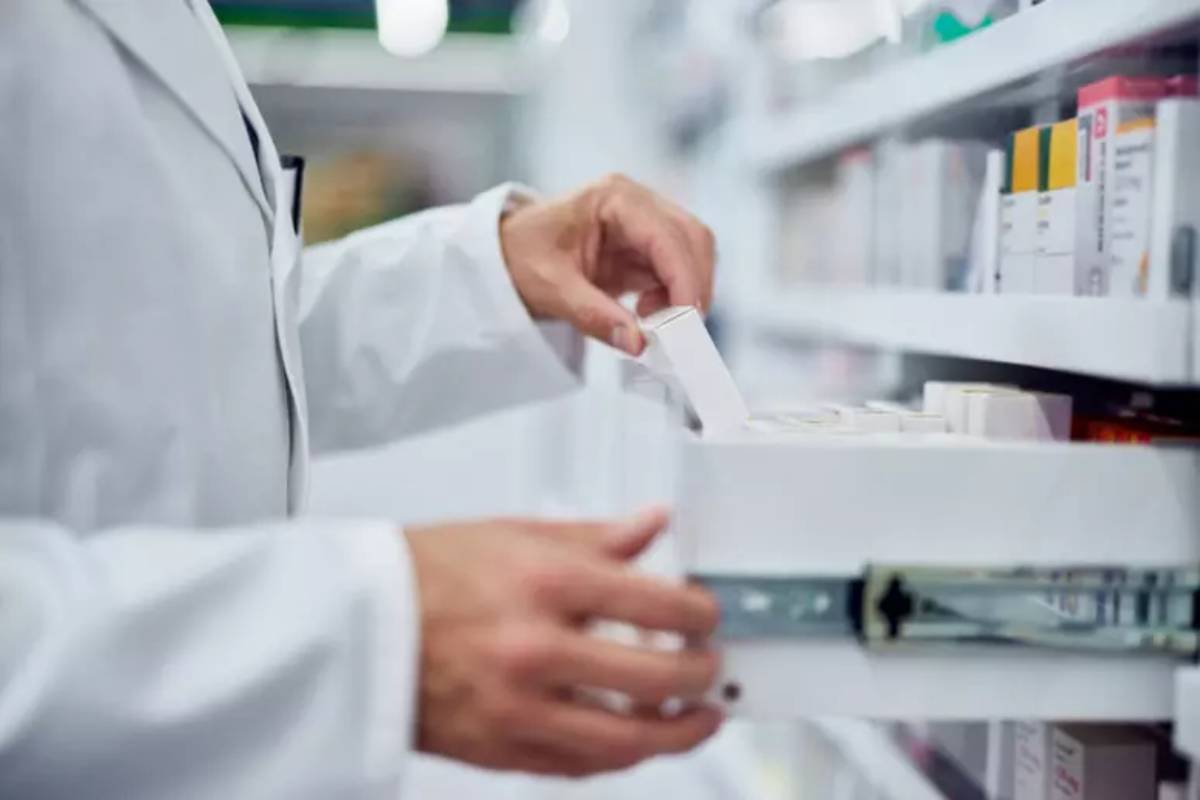 Un farmacista prende un farmaco da un cassetto 