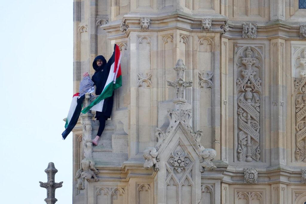 si arrampica sul big ben con bandiera palestina