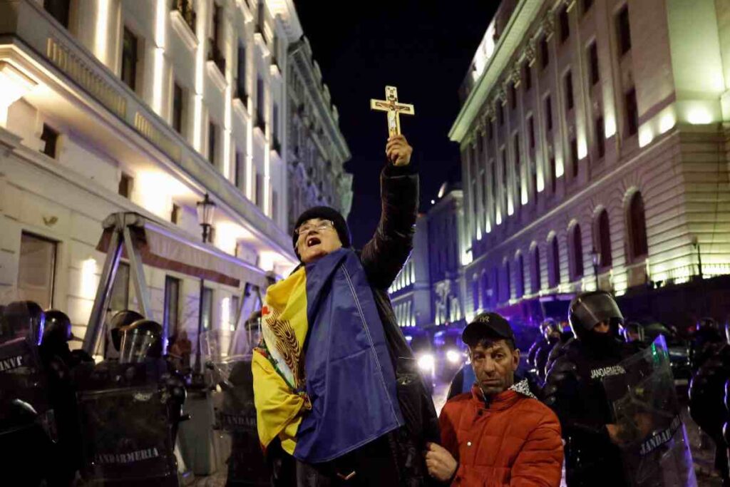 L'anziana sostenitrice di Georgescu che in Romania protesta in piazza con la croce ortodossa in mano